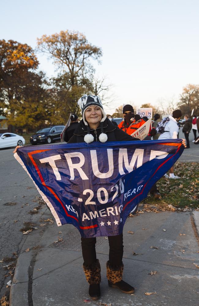 Genevieve Peters, from Detroit, waves a Trump flag among a group of Joe Biden supporters. Picture: News Corp Australia