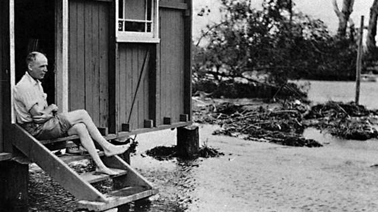 An unidentified man sitting on his house steps amid flood waters at Moondarewa, South Stradbroke Island, Queensland, 1938