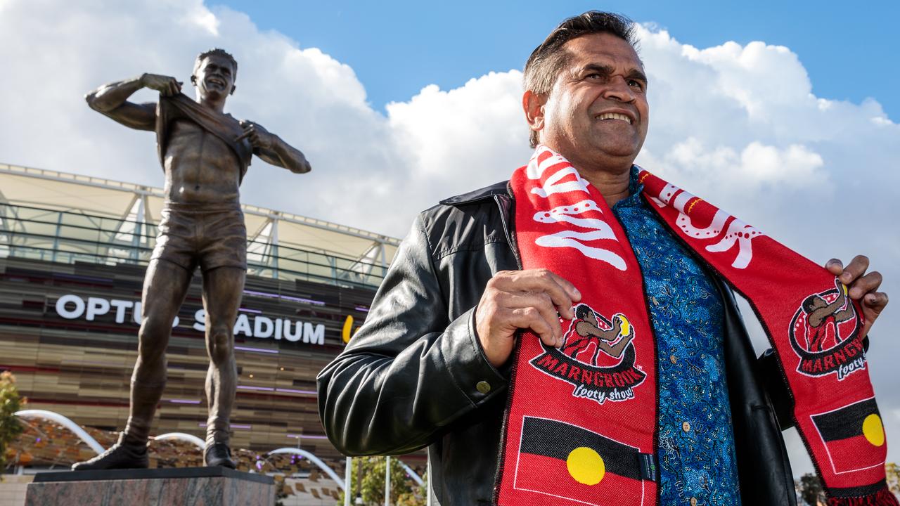 AFL legend Nicky Winmar poses in front of his statue at Optus Stadium in Perth. (AAP Image/Richard Wainwright)