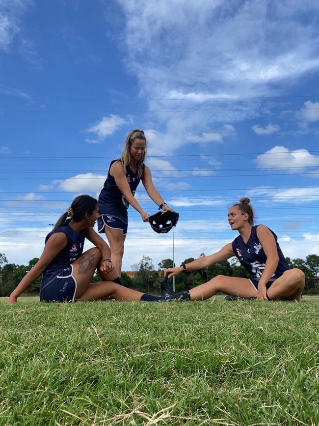 Jannifer Gomes (left) and Ebony Peterson (right) smell Lauren Jame's helmet (centre). SUPPLIED.