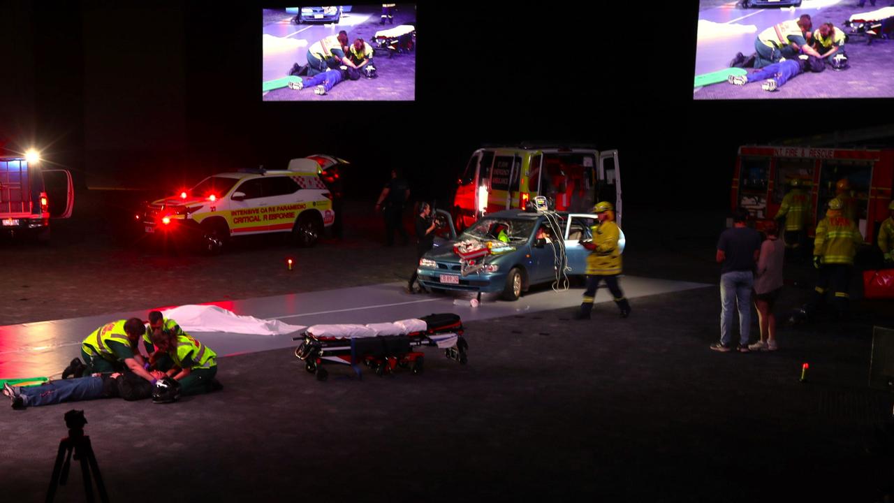 A scene from the re-enactment showing ambulance personnel treating a motorcyclist struck by an oncoming car. Picture: George Yankovich