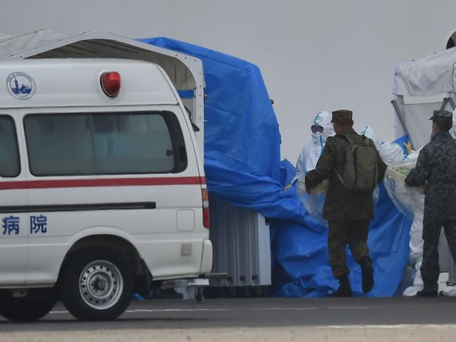 Military personnel and medical staff clad in protective gear are seen at work near the quarantined Diamond Princess cruise ship at Daikoku Pier Cruise Terminal in Yokohama. Picture: AFP