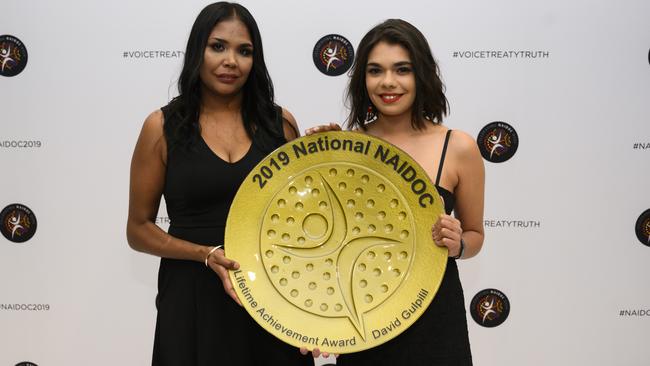 David Gulpilil's daughters Makia McLaughlin and Phoebe Marson with their father’s Lifetime Achievement Award at the 2019 National NAIDOC Awards. Picture: Rohan Thomson/Getty Images