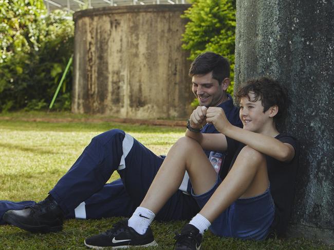 Richard Parker with Eli Jarick - the 13-year-old boy he saved at Pine Creek near Bundaberg in front of the tree Eli fell six metres from in March.