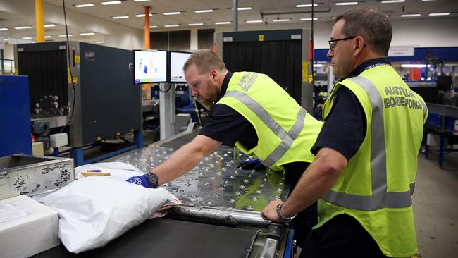 Border Force officials X-ray parcels at the Clyde facility in Sydney, where up to 200 contraband parcels are detected each day.