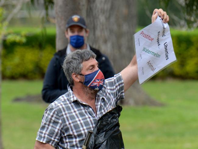 An anti-lockdown protester demonstrates near the Shrine of Remembrance before being arrested. Picture: Andrew Henshaw