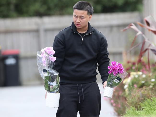 A family member takes flowers to the site. Picture: NewsWire/ David Crosling