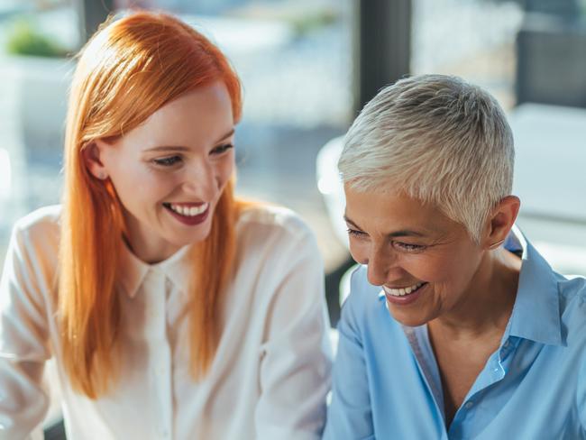 CAREERS: Two businesswomen working together on a computer in the office.