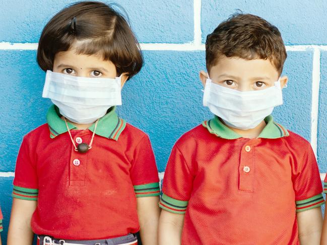 School preteen kids with protection face mask against new coronavirus, covid -19, nCov 2019 or sars cov 2 virus at school - children wore medical mask due to coronavirus outbreak