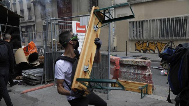 A protestor throws a wooden bench. Picture: AFP