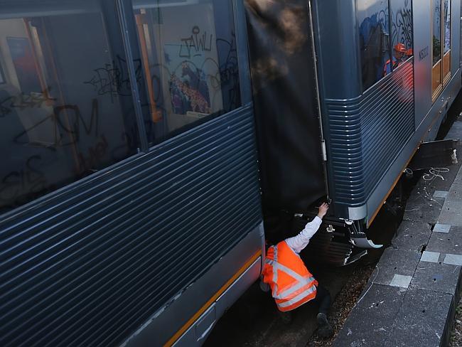 Workers inspect the derailed train.