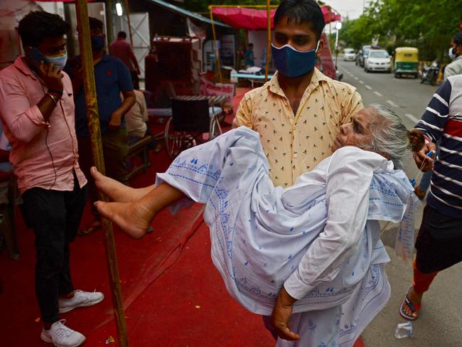 A family member carries a patient who is having difficulty in breathing, to a free oxygen support centre on the outskirts of New Delhi. Picture: AFP