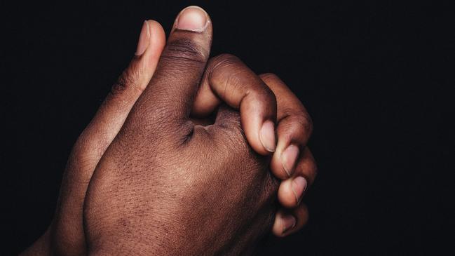 Black man hands clasped generic.