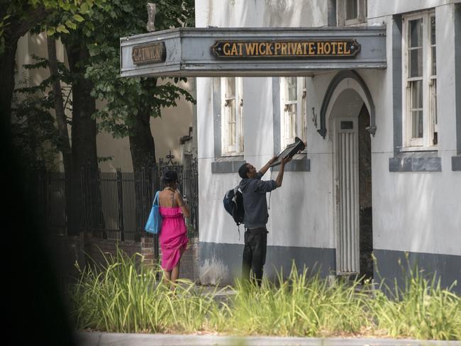 A man is seen passing a TV/monitor to a resident inside the Gatwick Hotel. Picture: Christopher Chan