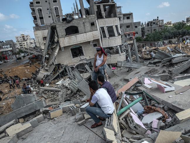 Men sit on the rubble of a residential building in Gaza. Picture: Fatima Shbair/Getty