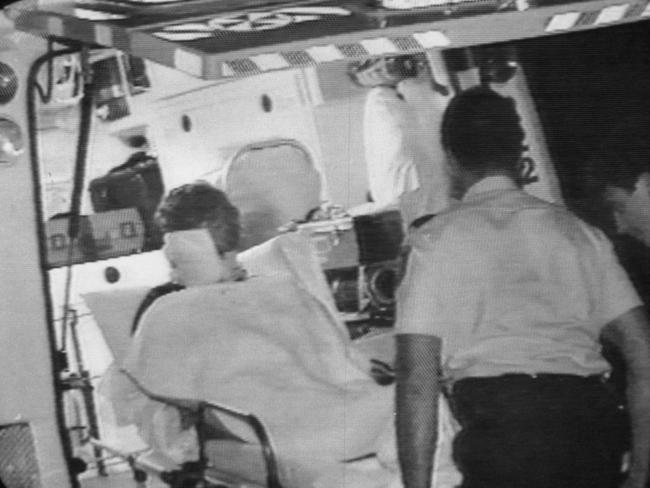 Christopher Gall, survivor of the massacre by Malcolm Baker is taken away in an ambulance.