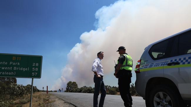 Police and Emergency Services Minister Michael Ferguson speaking to a police officer on Marlborough Rd at Miena today. Picture: LUKE BOWDEN