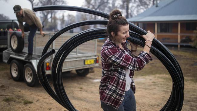 Leah with the new hose pipe the family bought after the fire. Picture: Sean Davey