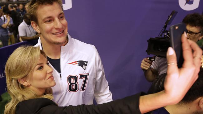 New England Patriots' Rob Gronkowski poses for a selfie with a television host.