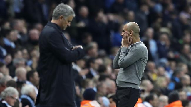 Manchester United manager Jose Mourinho, left, checks his watch next to Manchester City coach Pep Guardiola
