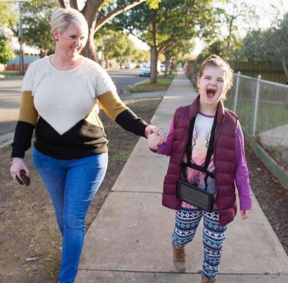 Peta Perrie holds the hand of her daughter Mia, 10, who has Angelman Syndrome, a rare neurological disorder. Picture: Inclusive Sport SA