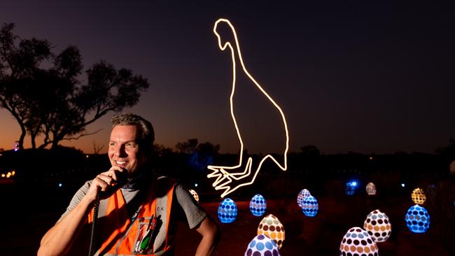 Chris Karstens, Parrtjima Desert Park Precinct Manager prepares for Parrtjima in front of Emu Laying Eggs at Night by Lachlan Dodds-Watson