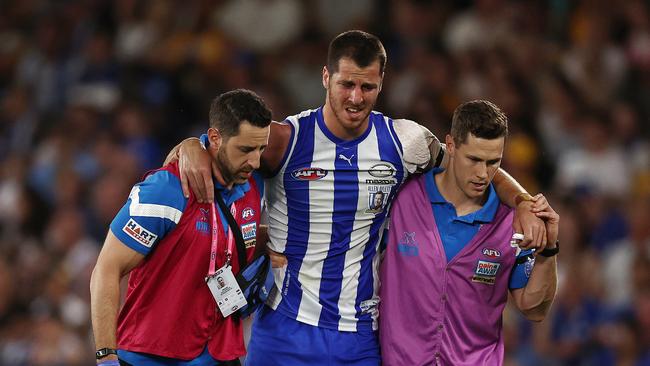 Tristan Xerri of the Kangaroos is helped off the ground after injuring his ankle during the first quarter in round one last season. Picture: Michael Klein