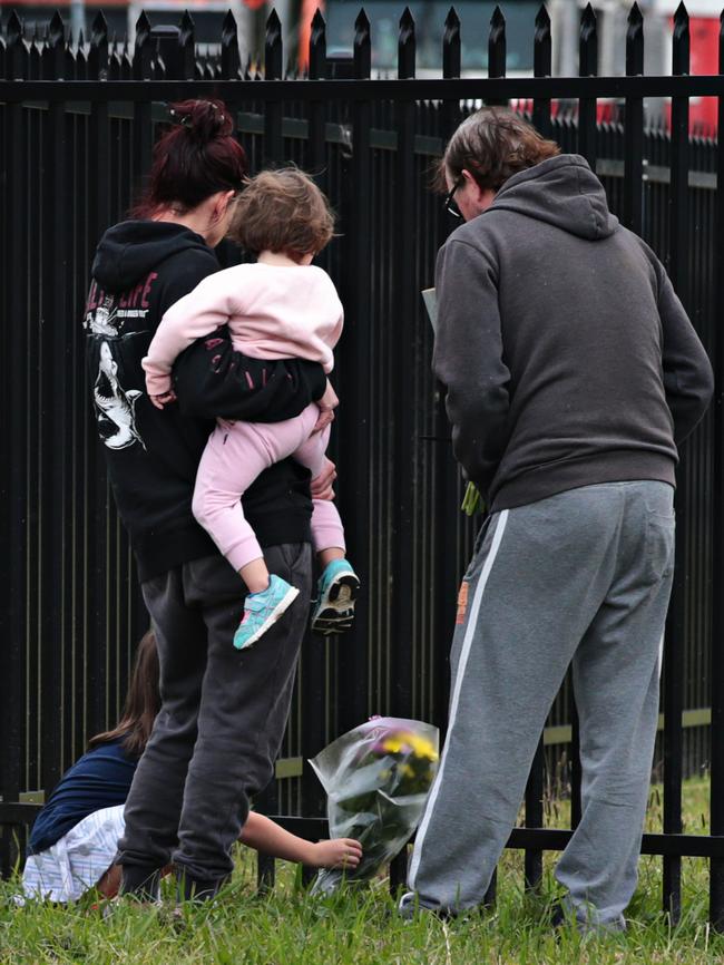 People lay flowers at the depot where the young boy died. Picture: Adam Yip