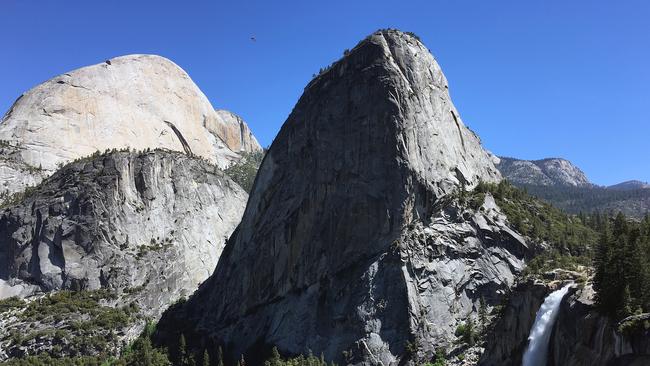 Liberty Cap, a 2100-metre granite monolith, soars over Nevada Fall in the foreground and Half Dome in the background, inside the Yosemite National Park in California.