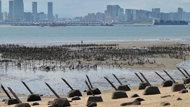 The Xiamen city skyline on the Chinese mainland is seen past anti-landing spikes placed along the coast of Lieyu islet on Taiwan's Kinmen islands, which lie just 3.2km from the mainland China coast. Picture: AFP