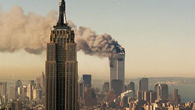 The twin towers of the World Trade Center burn behind the Empire State Building in New York.