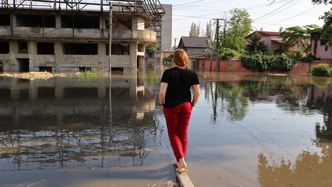 A woman looks at a flooded street Kherson. Picture: AFP