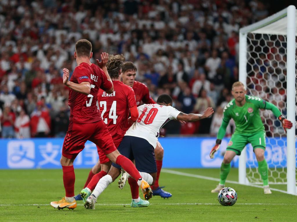 Raheem Sterling goes down under pressure from Mathias Jensen in the crucial moment. Joakim Maehle puts his hands up after making contact with Sterling’s leg. (Photo by Alex Morton – UEFA/UEFA via Getty Images)