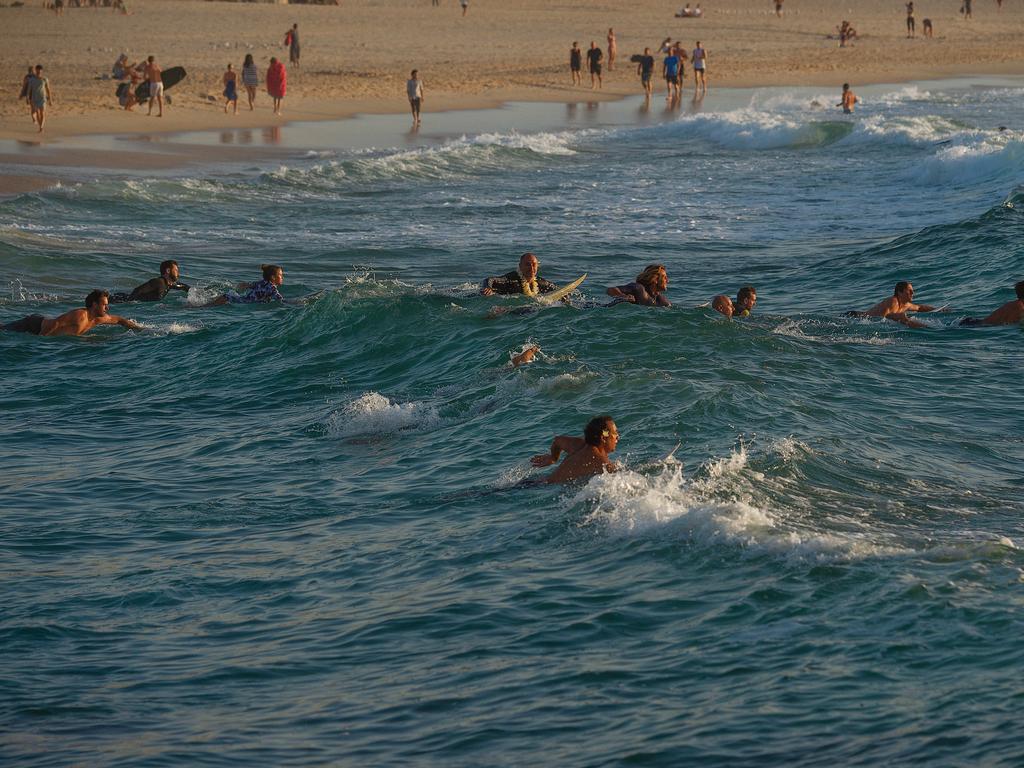 Surfers making there way out to sea to pay tribute to Annalise Braakensiek at the Memorial held at Bondi Beach around 7am Wednesday January 16 Image Picture: Monique Harmer