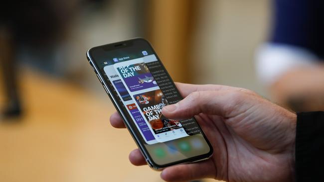 In this file photo taken on November 3, 2017 an Apple employee demonstrates the app switcher on the iPhone X at the Apple Store Union Square, in San Francisco, California. (Photo by Elijah Nouvelage / AFP)