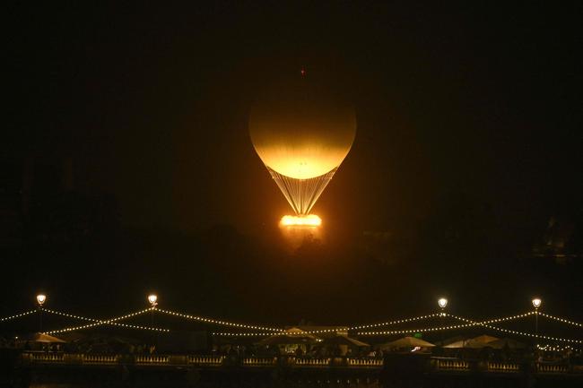 The cauldron, with the Olympic flame lit, lifts off while attached to a balloon, during the opening ceremony of the Paris 2024 Olympic Games in Paris on July 26, 2024 (Photo by Philippe Lopez / AFP)