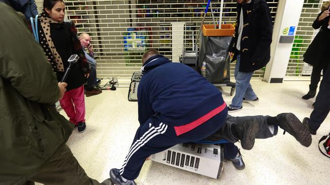 Customers fall to the floor as they grapple for an LED television during a Black Friday discount sale at an Asda supermarket, operated by Wal-Mart Stores Inc., in the Wembley district of London, U.K., on Friday, Nov. 28, 2014. Black Friday has caught on in the U.K. and worldwide over the last few years as the rise of the Internet has made the event a global phenomenon, with customers always being just one click away from the deals offered by U.S. retailers online. Photographer: Simon Dawson/Bloomberg via Getty Images