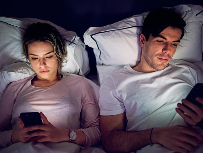 Mobile phone addiction - couple is texting and browsing in the bed