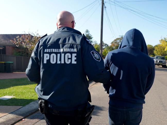 This undated handout photo provided by the Australian Federal Police (AFP) on September 18, 2024, shows an Australian Federal Police officer arresting a suspect allegedly involved in an encrypted messaging app used by criminals worldwide to facilitate drug deals and order killings, at an unknown location.Â . Australian Federal Police said the app -- known as Ghost -- was marketed as "unhackable" and was used by hundreds of suspected criminals from Italy, the Middle East and Asia. (Photo by Handout / AUSTRALIAN FEDERAL POLICE / AFP) / RESTRICTED TO EDITORIAL USE - MANDATORY CREDIT "AFP PHOTO / AUSTRALIAN FEDERAL POLICE" - NO MARKETING NO ADVERTISING CAMPAIGNS - DISTRIBUTED AS A SERVICE TO CLIENTS