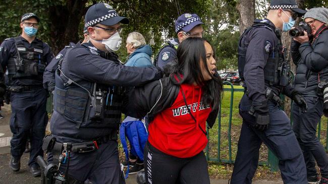 Police on a Flemington housing estate detain a woman before later releasing her. Picture: Tim Carrafa