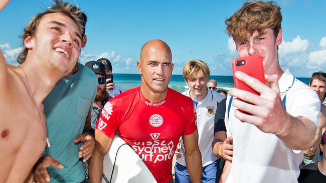 Surfing legend Kelly Slater is mobbed by fans after being eliminated in Round 3, Heat 5 of the Vissla Sydney Surf Pro at Manly Beach on Thursday March 21. AAP IMAGE / Troy Snook)