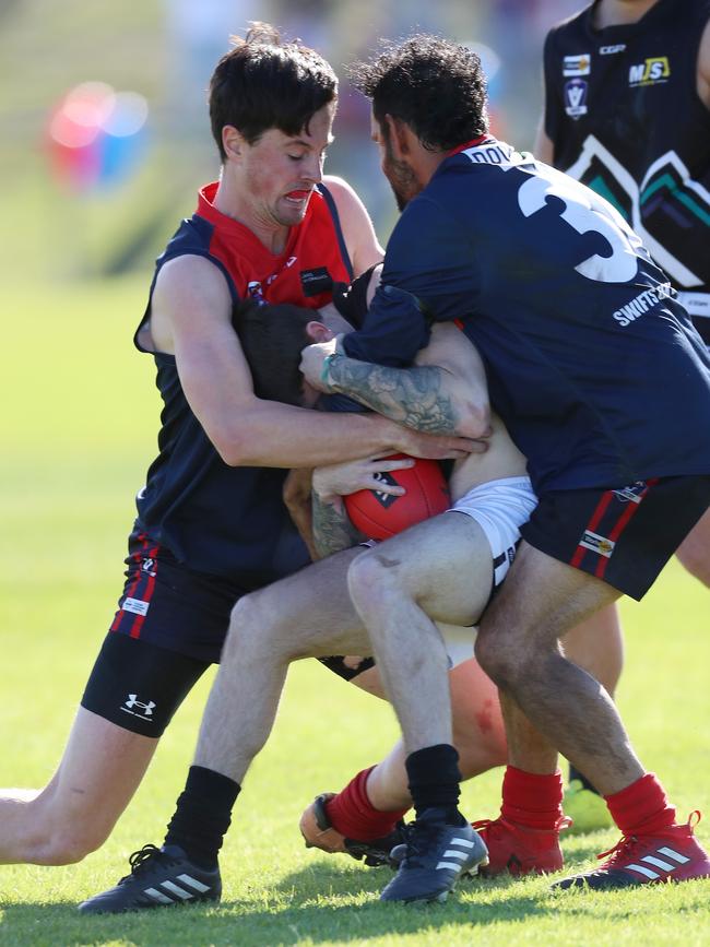 Swifts Creek’s Daniel O'Brien and Nathan Hayes gang tackle Omeo-Benambra’s Jacob Tomkins.