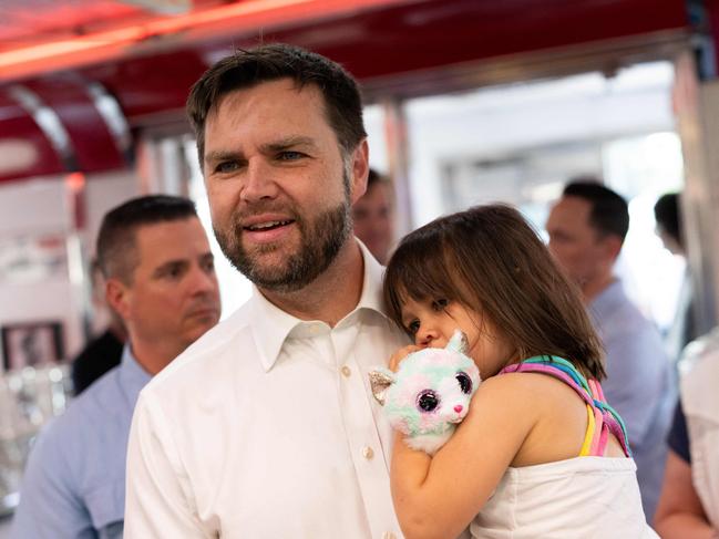 US Republican vice presidential nominee JD Vance carries his daughter Maribel Vance as he arrives to greet supporters at the Park Diner on Sunday. Picture: AFP