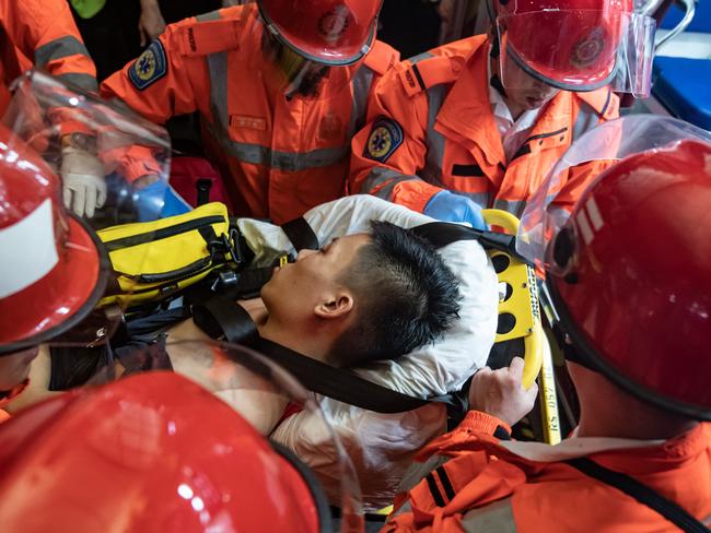 An injured man, who was suspected by protesters of being an undercover police officer, is taken away by paramedics. Picture: Getty