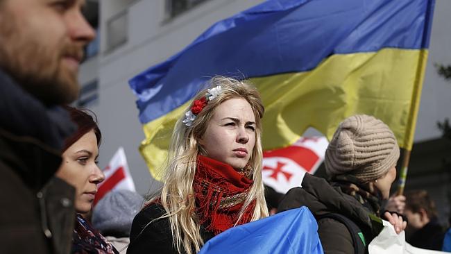A woman wearing a traditional Ukrainian headband demonstrates outside the Russian Embassy in Paris.