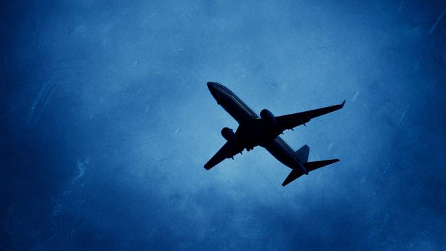 airplane on silhouette flying under a menacing sky. overlay texture grunge