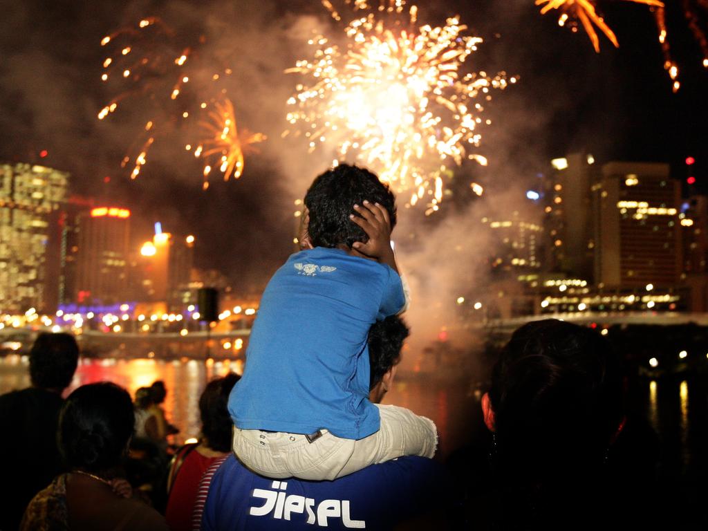 Varun Pillai holds his ears as New Year’s Eve fireworks light up over the river in Brisbane 2008. Photo: Courier Mail archives