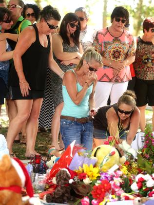 A group of women lay flowers at the memorial in Manoora. Pic: Mark Calleja