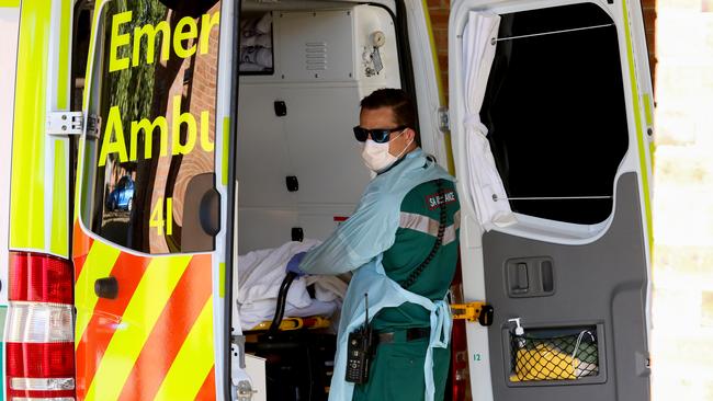 A paramedic wears protective clothing while transporting a patient at the new Covid-19 Clinic at the Mount Barker Hospital in Adelaide. (AAP Image/Kelly Barnes)