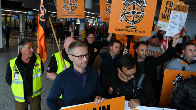 Airport workers and unionists attend a protest in terminal four at Melbourne Airport in Melbourne, Friday, November 8, 2019. Protesters are calling on airports and airlines to address the low wages, lack of full-time secure jobs and safety issues that workers face. (AAP Image/James Ross)